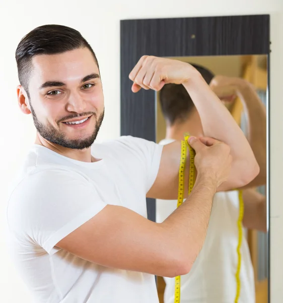 Mann misst seinen Bizeps — Stockfoto