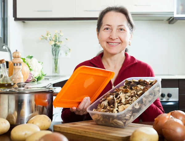 Vrouw koken soep met paddestoelen — Stockfoto