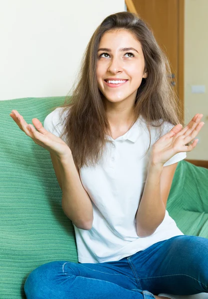 Chica haciendo gestos mientras está sentado en el sofá —  Fotos de Stock