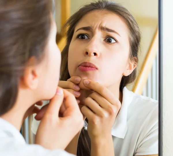 Woman squeezing spot with fingers — Stock Photo, Image