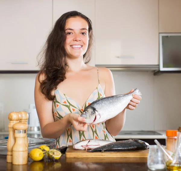 Mujer cocinando peces en la cocina —  Fotos de Stock