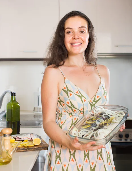 Mulher cozinhar peixes na cozinha — Fotografia de Stock