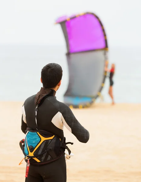 Dva dospělí s kiteboardon na pláži — Stock fotografie