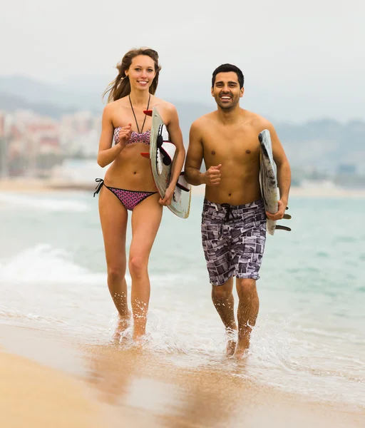 Young surfers couple on the beach — Stock Photo, Image