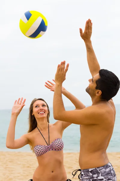 Пара, играющая с мячом на пляже — стоковое фото