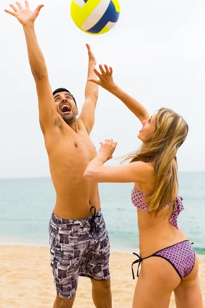 Пара грає з м'ячем на пляжі — стокове фото