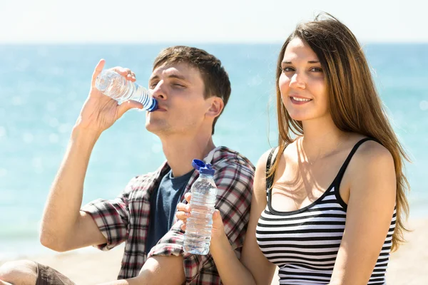 Young travelers drinking bottled water — Stock Photo, Image