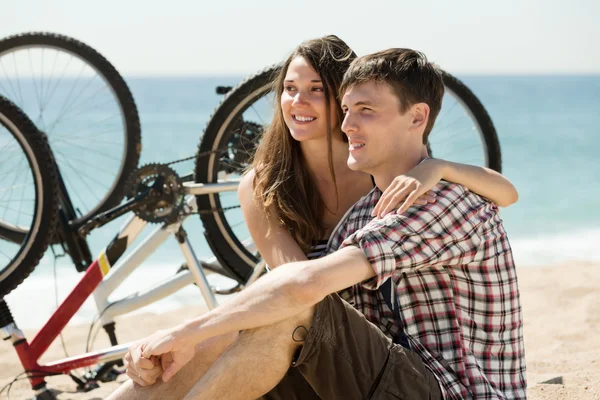 Paar mit Fahrrädern am Strand — Stockfoto