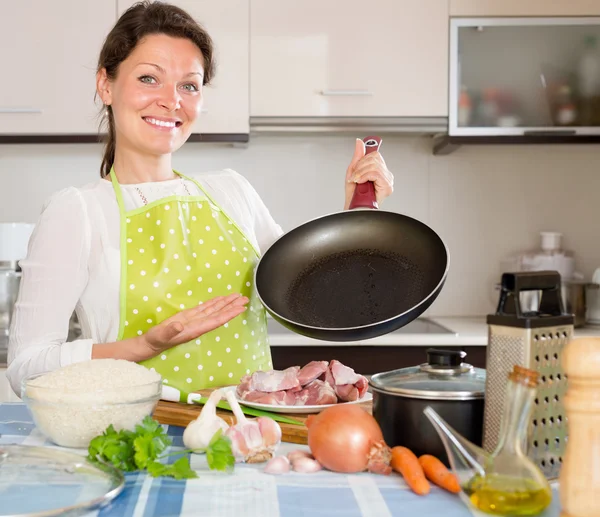 Mujer sonriente preparando carne con arroz — Foto de Stock