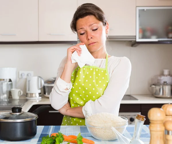 Грустная женщина готовит рис на кухне — стоковое фото