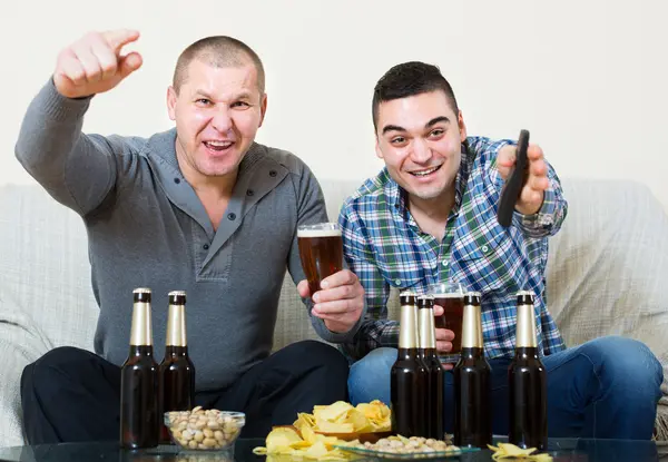 Friends sitting at table with beer — Stock Photo, Image