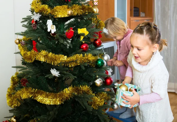 Children hanging decorations on fir — Stock Photo, Image