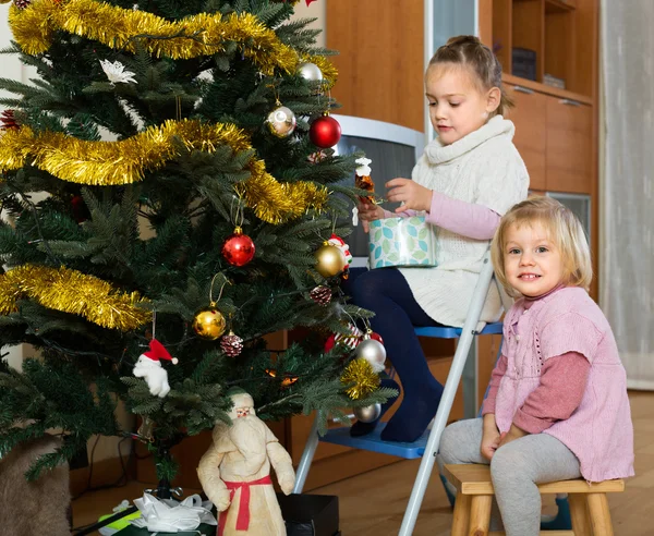 Två små flickor dekorera julgran — Stockfoto