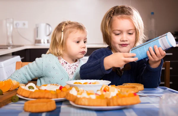 Hermanas comiendo pastelería en la cocina —  Fotos de Stock