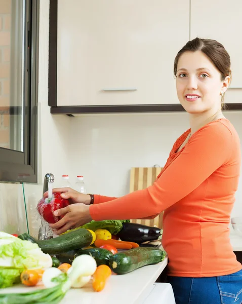 Jeune femme laver les légumes frais — Photo