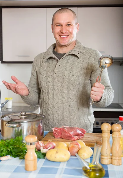 Χαμογελαστός άνθρωπος στην εγχώρια κουζίνα — Φωτογραφία Αρχείου