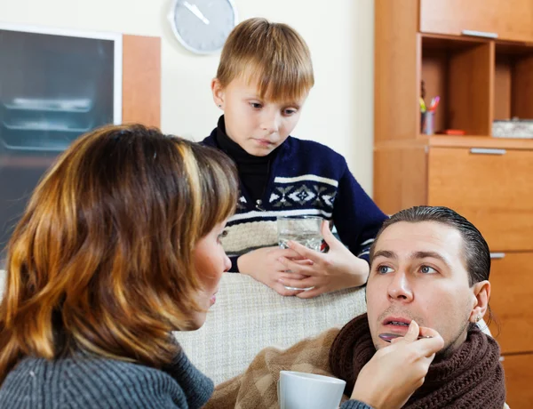 Ziekelijke man omgeven door vrouw en zoon — Stockfoto