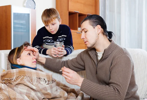Man and son caring for unwell woman — Stock Photo, Image