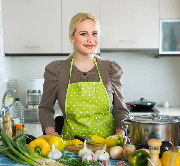 Vrouw in schort aan huis keuken — Stockfoto