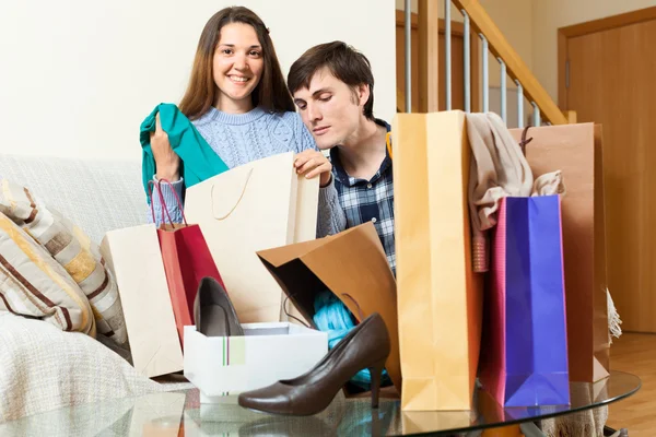 Guy and girl looking their  purchases — Stock Photo, Image