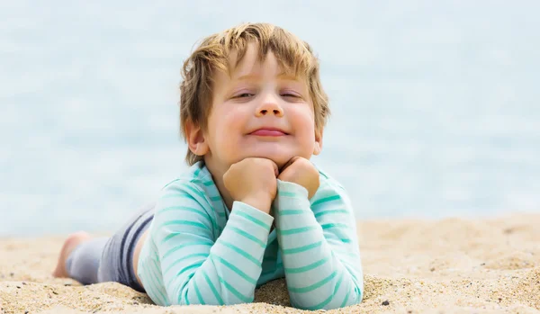 Chica sonriente tendida en la playa — Foto de Stock