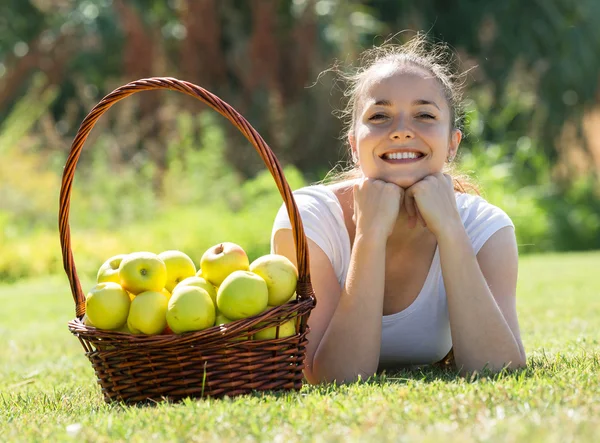 Menina com uma cesta de maçãs — Fotografia de Stock