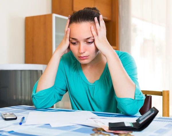 Traurige Frau mit Geldscheinen am Tisch — Stockfoto