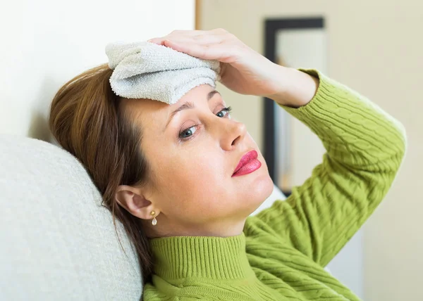 Female with wet towel on forehead — Stock Photo, Image
