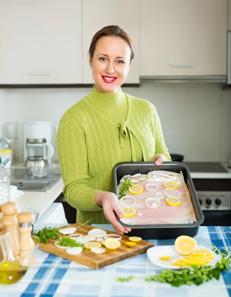 Ama de casa cocinando pescado fileteado — Foto de Stock