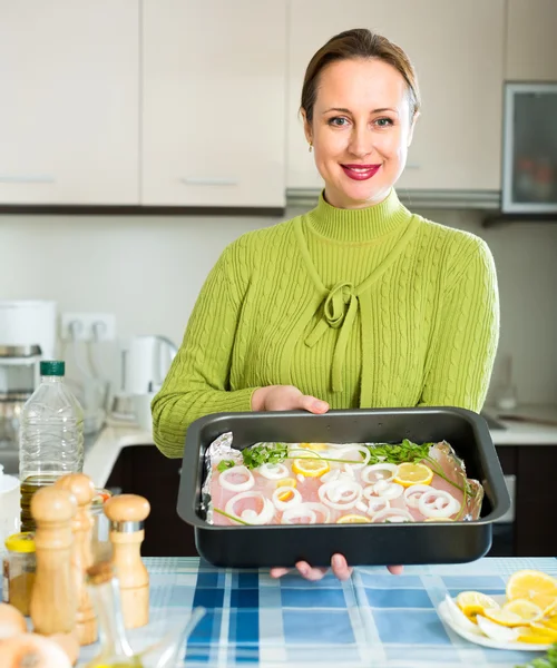 Attractive housewife cooking fish — Stock Photo, Image