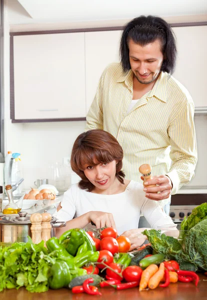 Femme au foyer avec homme cuisinant avec des légumes frais — Photo