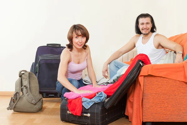 Pár spolu se zavazadly balení oblečení — Stock fotografie