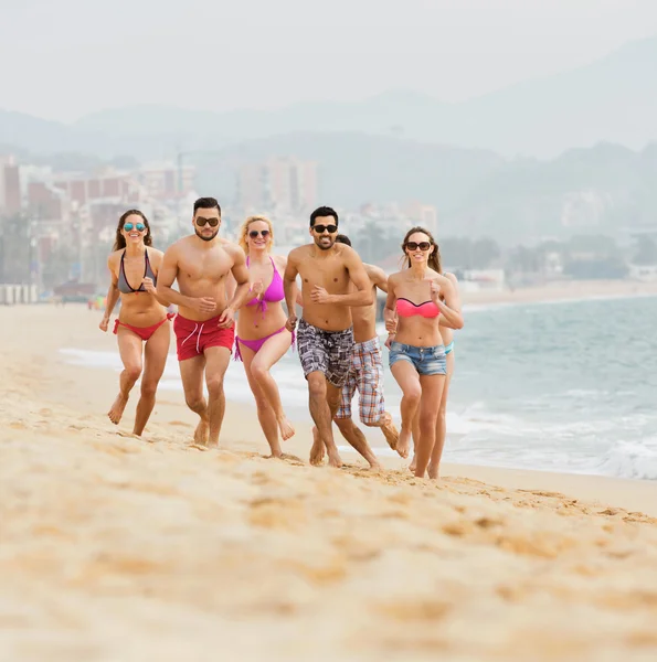 Groupe de personnes courant sur la plage de la mer — Photo