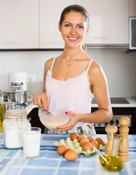 Happy girl cooking omelette with milk — Stock Photo, Image