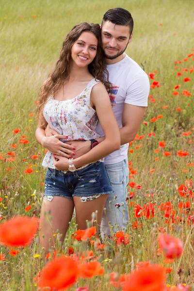 Couple in red poppies — Stock Photo, Image