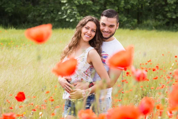Paar in roten Mohnblumen — Stockfoto