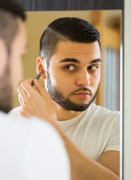Handsome man remove hair with pincer — Stock Photo, Image