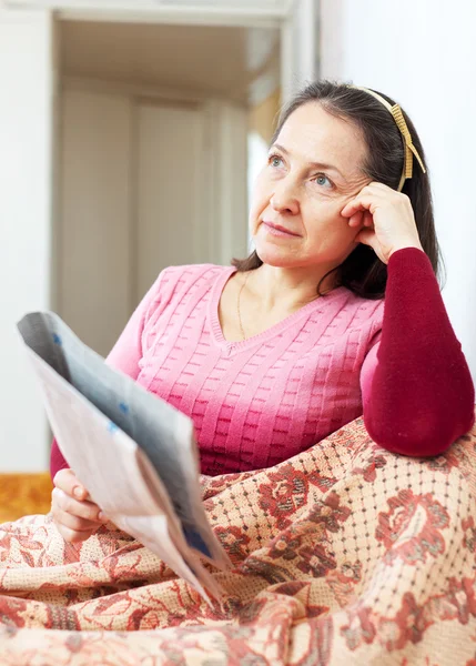 Wehmütige Frau liest Zeitung — Stockfoto