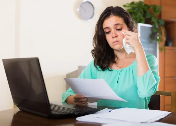 Sad woman with documents and laptop — Stock Photo, Image