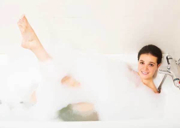 Menina que estabelece com espuma no banho — Fotografia de Stock