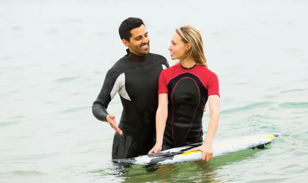 Surfistas casal cintura profunda no mar — Fotografia de Stock