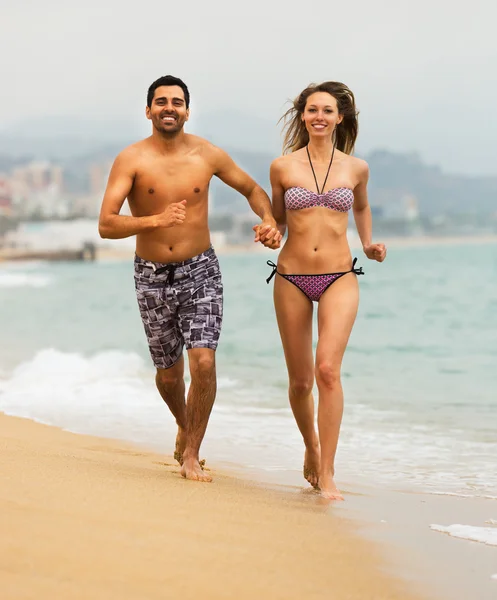 Casal jovem corre perto do mar — Fotografia de Stock