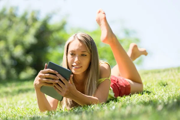 Sonriente chica leyendo ereader —  Fotos de Stock