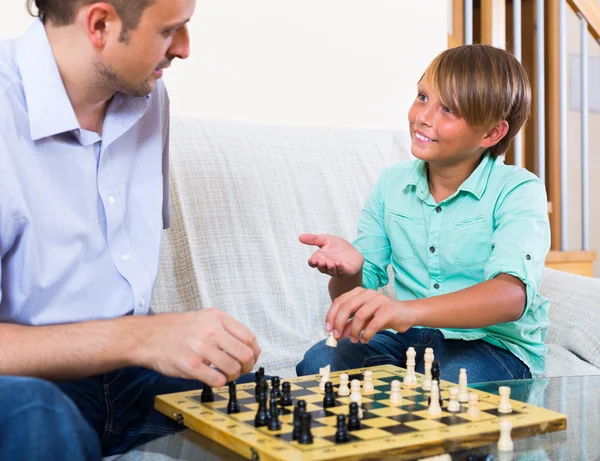 Man and teenager son playing chess — Stock Photo, Image