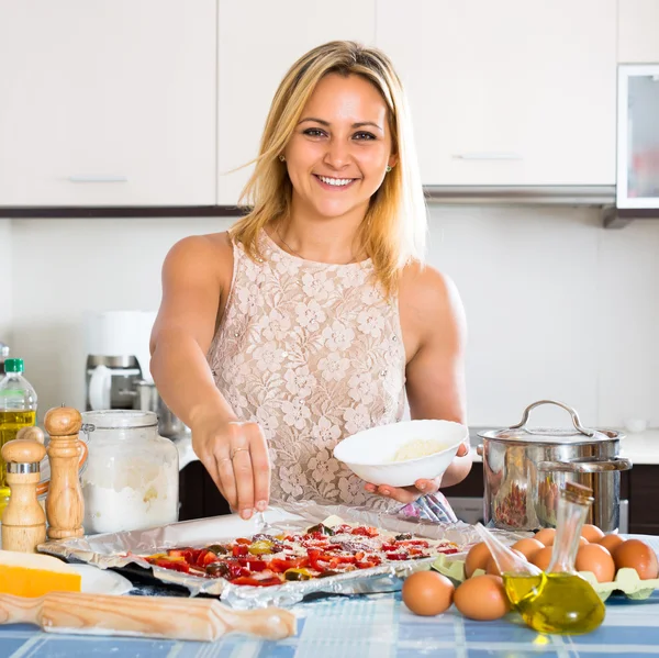 Žena vaření pizza se salámem — Stock fotografie