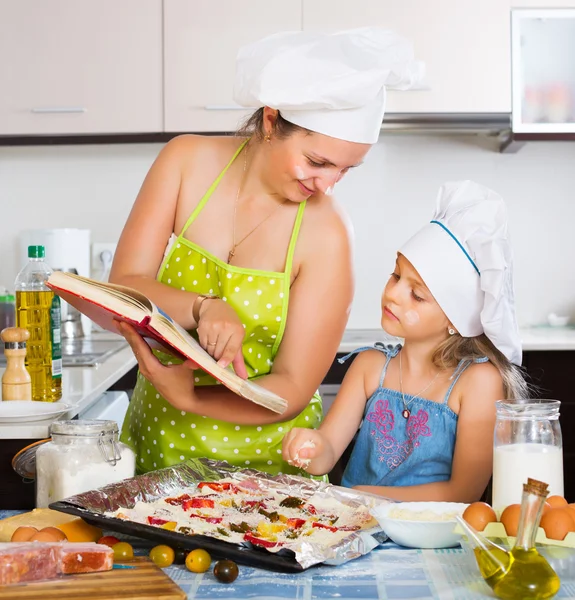 Mamá e hija decorando pizza —  Fotos de Stock