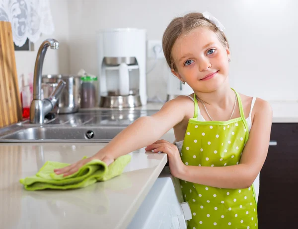 Cute little girl cleaning at kitchen — Stock Photo, Image