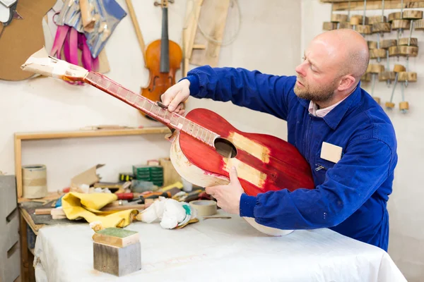 Сумасшедший, работающий с незаконченной гитарой — стоковое фото