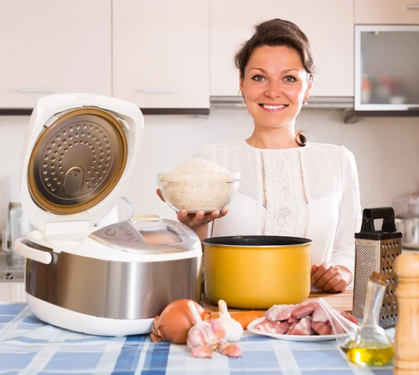 Женщина готовит с multicooke — стоковое фото