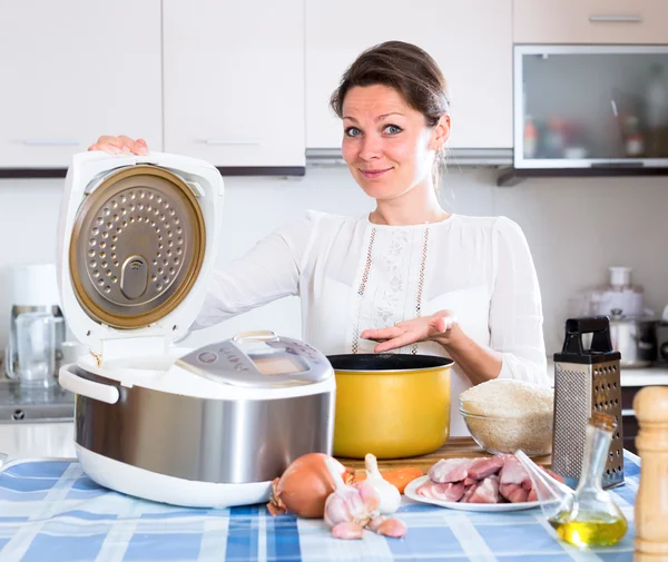 Домохозяйка готовит ужин в мультикукере — стоковое фото